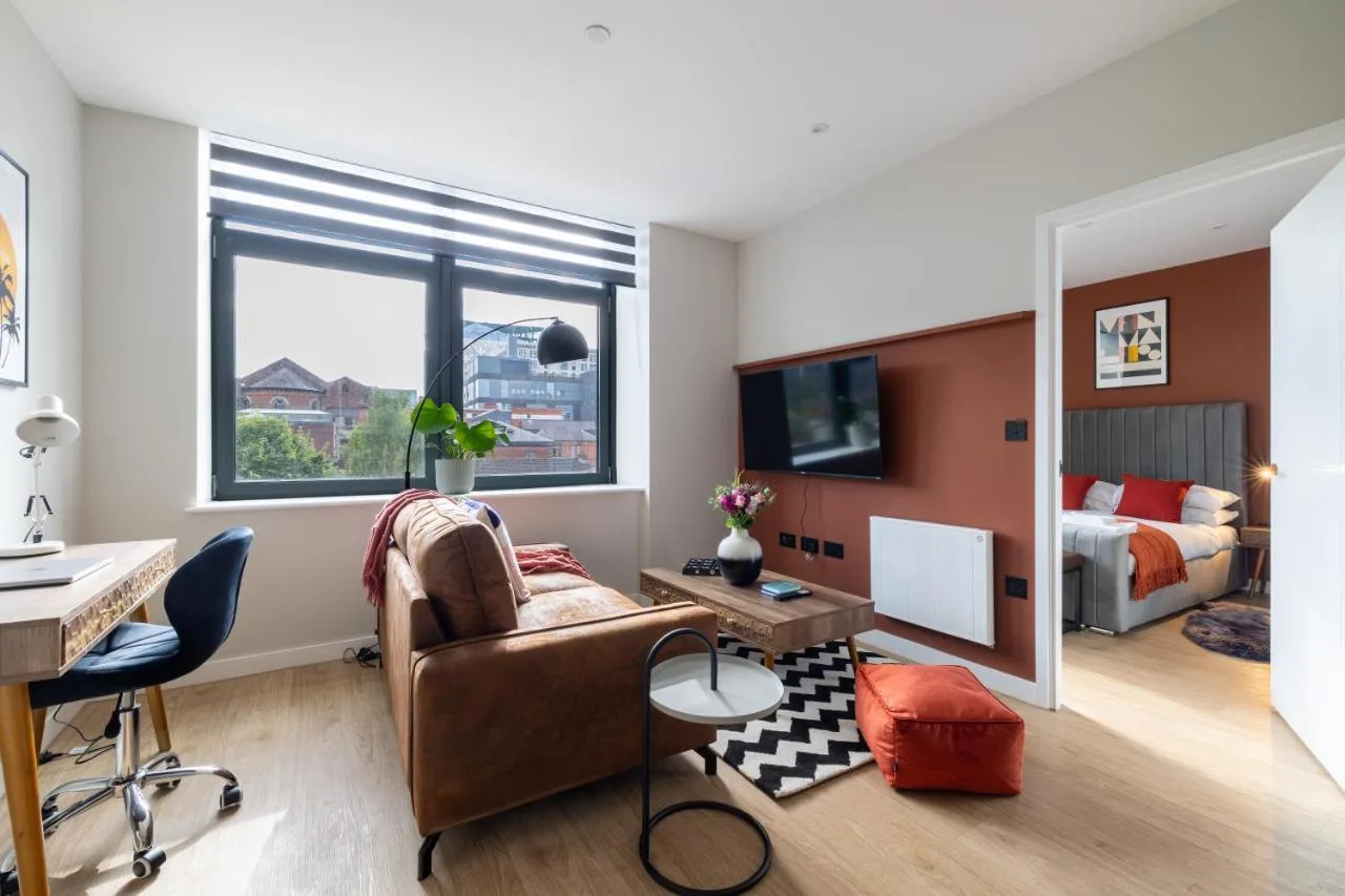 A living room with a desk and a bedroom at Kula Birmingham - New Street Station