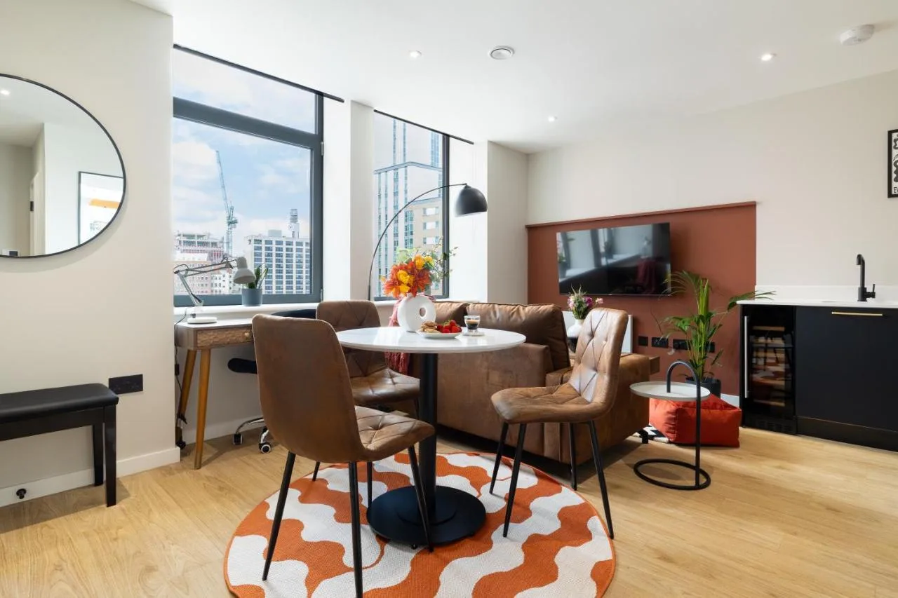 A living room with a table and chairs at Kula Birmingham - New Street Station