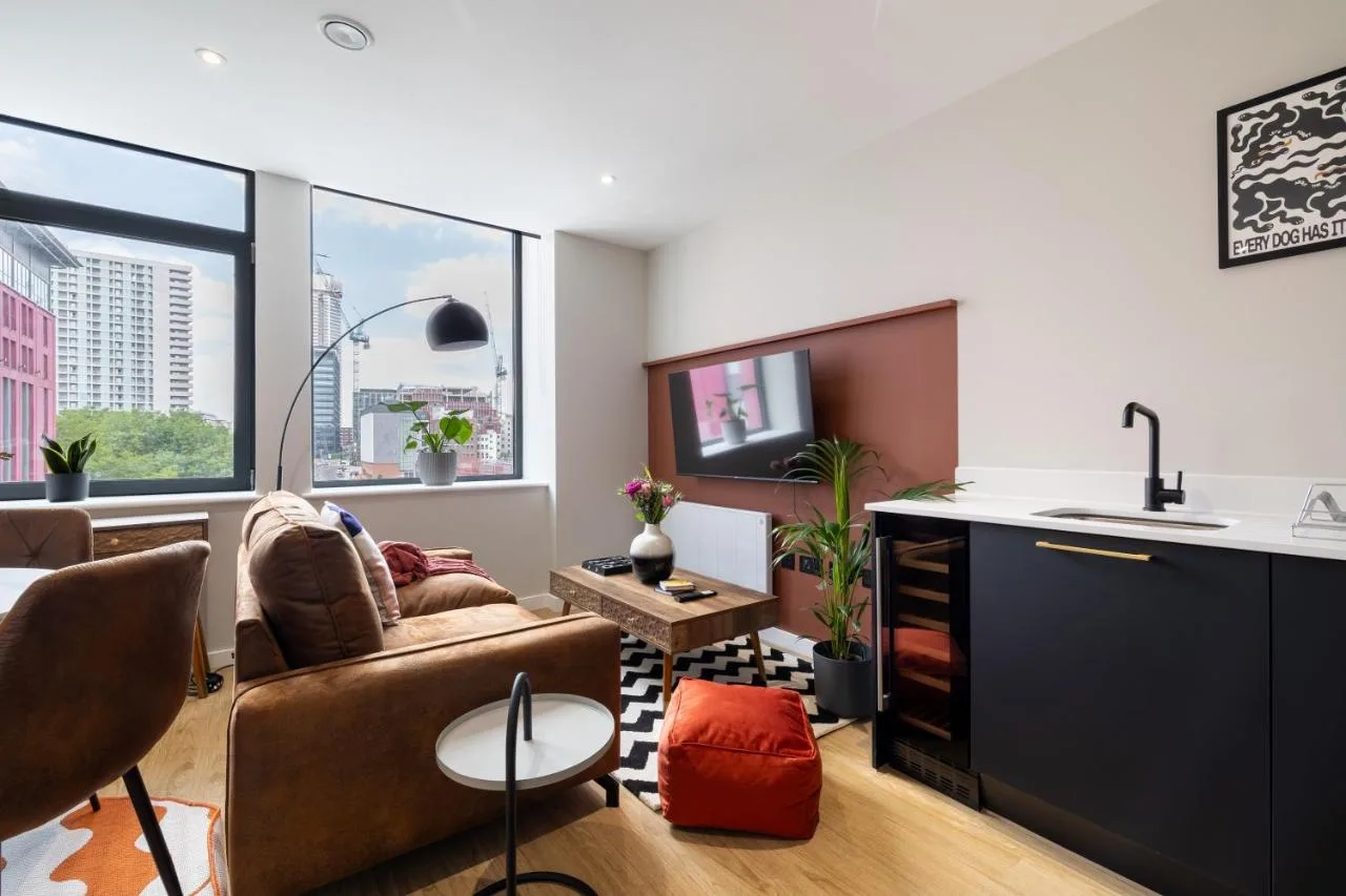 A living room with a couch and a TV at Kula Birmingham - New Street Station
